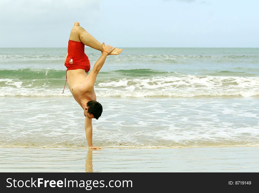 Man handstand on one hand on the caribbean beach. Man handstand on one hand on the caribbean beach