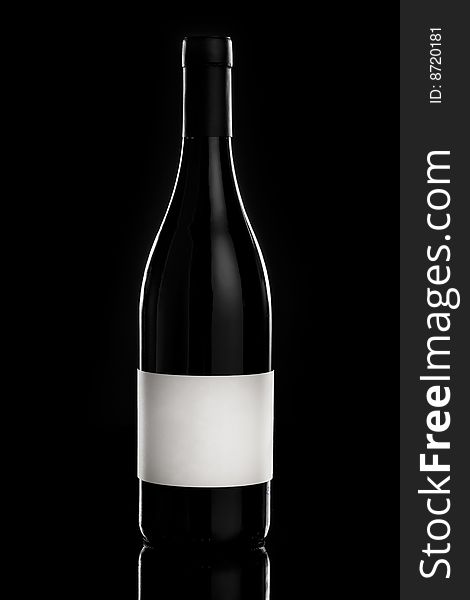 Red wine bottle over a black background with empty label