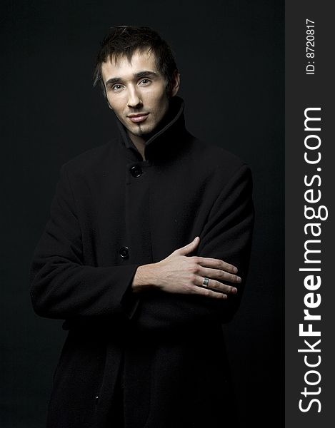 Portrait of a young business man with his hands on a dark background. Portrait of a young business man with his hands on a dark background