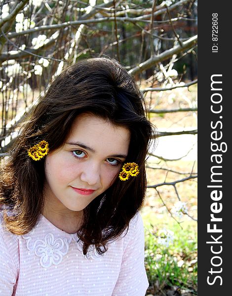 A teenage girl with yellow spring flowers in her hair. A teenage girl with yellow spring flowers in her hair.