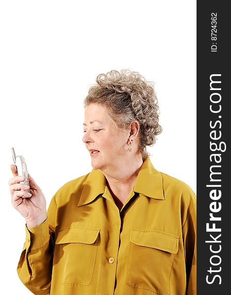 A senior woman in an dark yellow jacket dialing a number on her cell phone. On white background. A senior woman in an dark yellow jacket dialing a number on her cell phone. On white background.