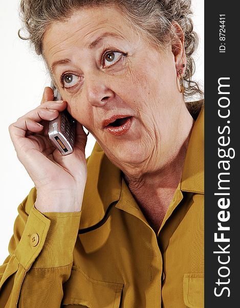 A senior woman in an dark yellow jacket talking on the
cell phone. On white background. A senior woman in an dark yellow jacket talking on the
cell phone. On white background.