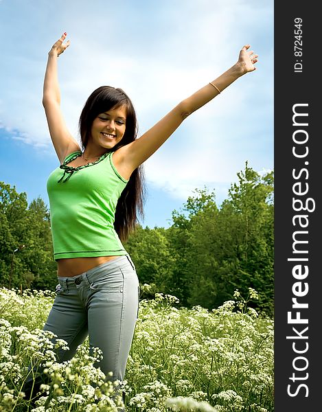 The happy girl on a blossoming meadow