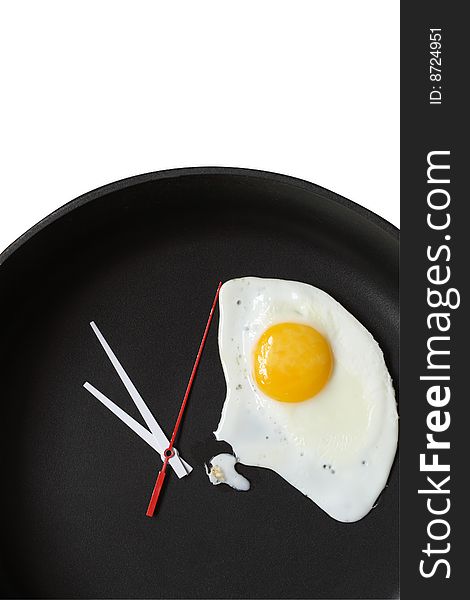 Clock hands and fried egg lying on black frying pan. Clock hands and fried egg lying on black frying pan