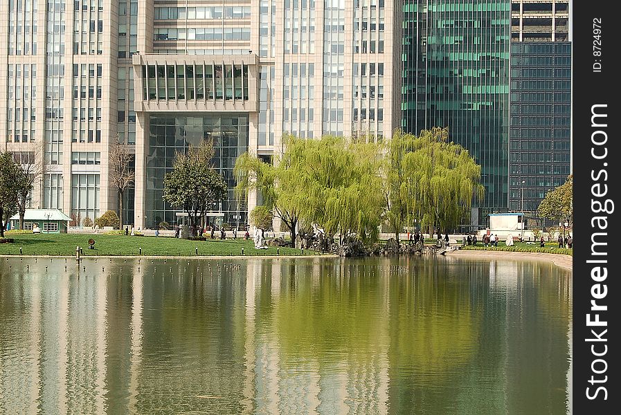 Office buildings, willows and their reflections in pond. shot at Pu dong, Shanghai in early spring. Office buildings, willows and their reflections in pond. shot at Pu dong, Shanghai in early spring.