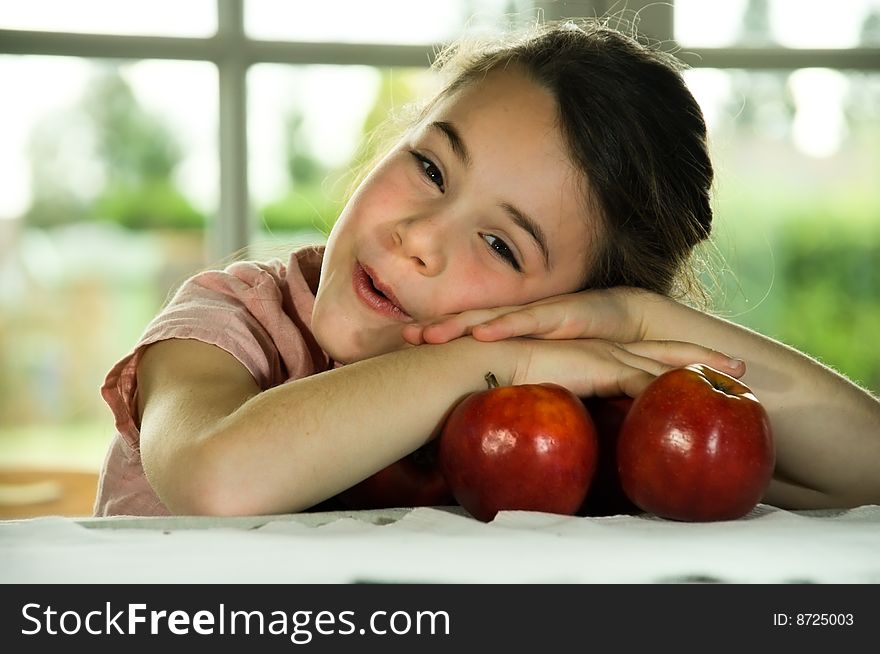 Brown haired child playing with apples. Healthy lifstyle image.