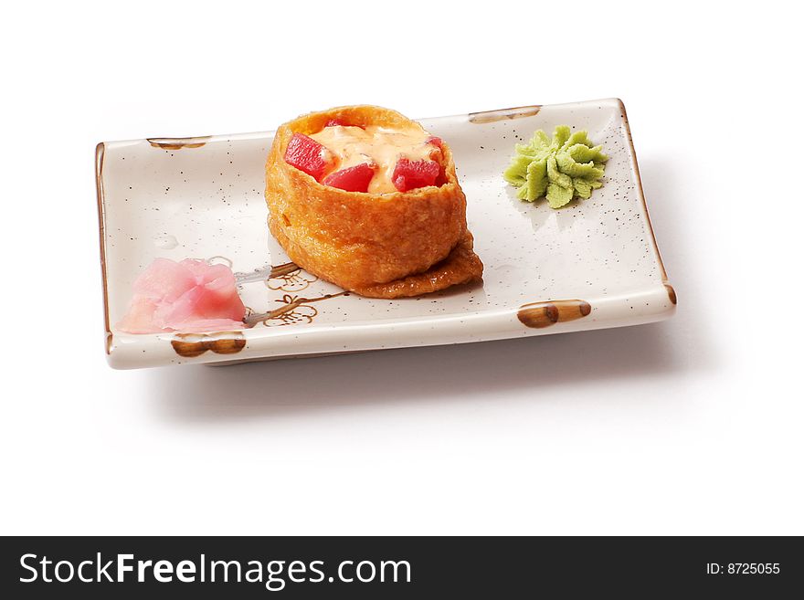 Sushi with tuna, cheese and ginger in white squared plate over white background