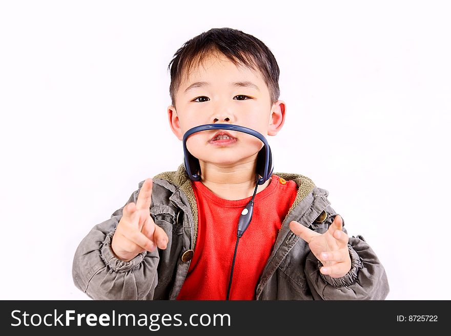 A picture of a little chinese boy listening to music with earphone, having great fun. A picture of a little chinese boy listening to music with earphone, having great fun