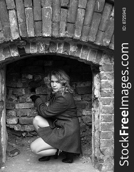 Girl sitting in a brick recess