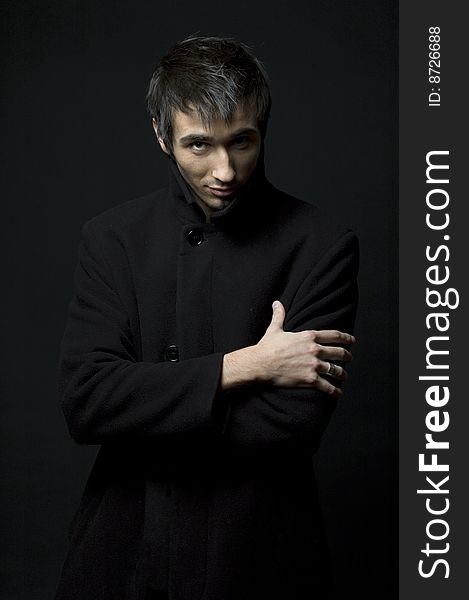 Portrait of a young business man with his hands looking strangeon a dark background. Portrait of a young business man with his hands looking strangeon a dark background