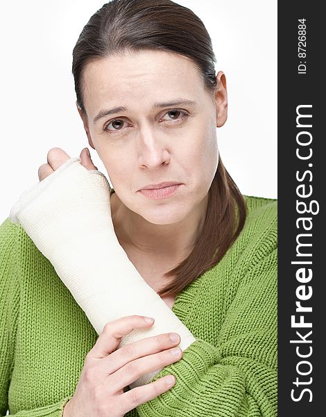 An upset woman with an arm injury on a white background