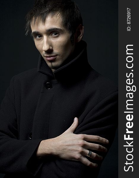 Portrait of a young business man with his hands on a dark background. Portrait of a young business man with his hands on a dark background