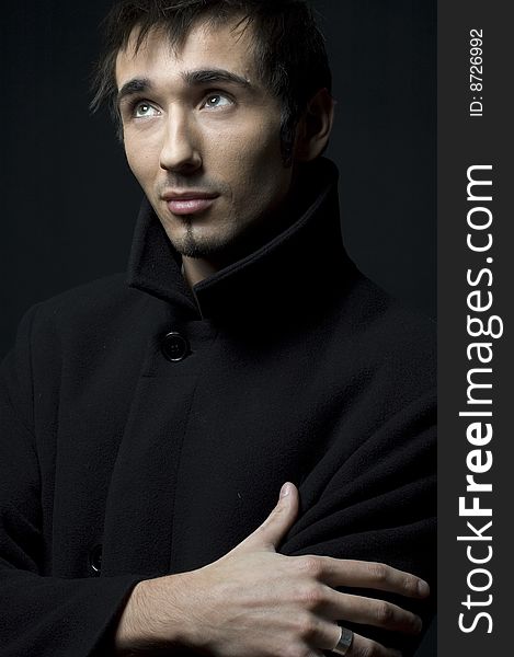 Portrait of a young business man with his hands on a dark background. Portrait of a young business man with his hands on a dark background