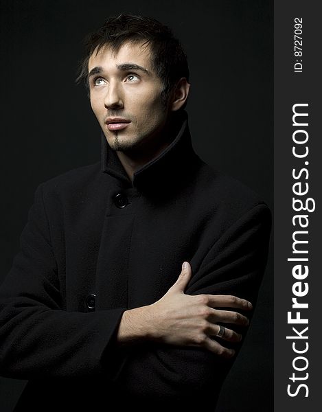 Portrait of a young business man with his hands on a dark background. Portrait of a young business man with his hands on a dark background