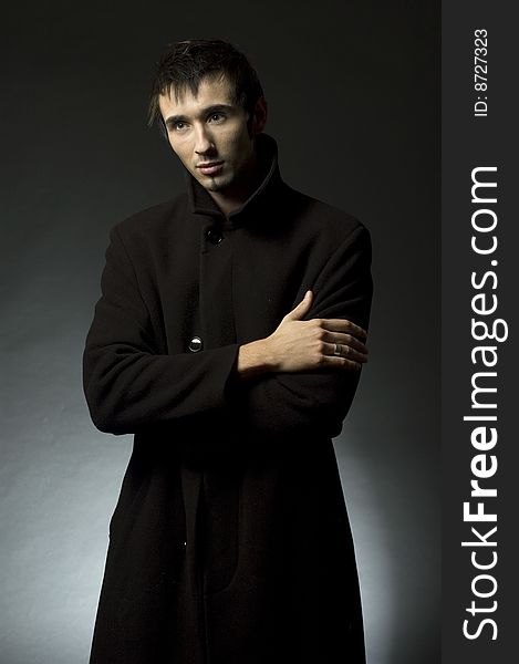 Portrait of a young business man with his hands on a dark background. Portrait of a young business man with his hands on a dark background