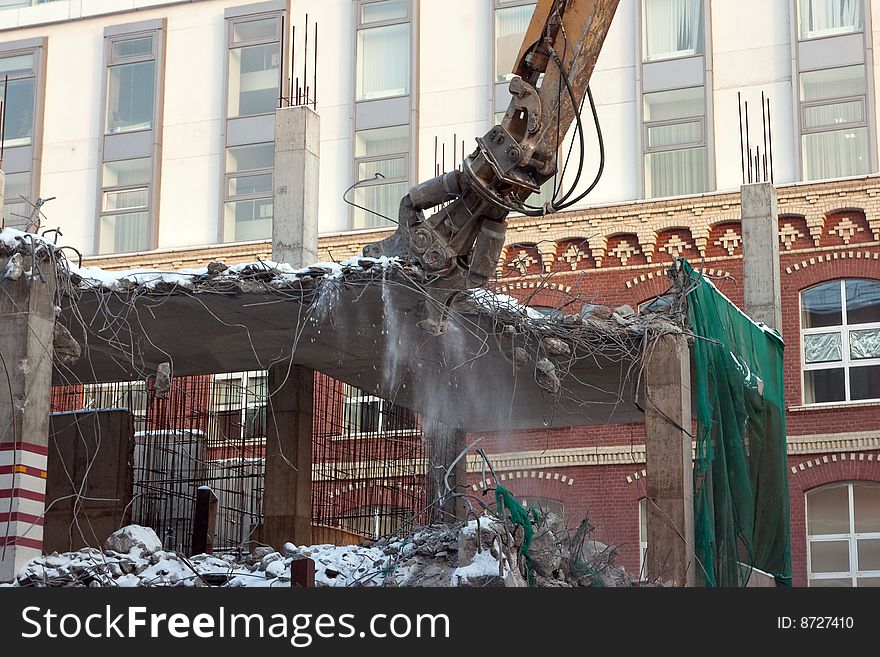 Heavy dredger is demolishing a house. Heavy dredger is demolishing a house