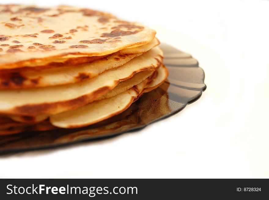 Plate with Russian pancakes on a white background