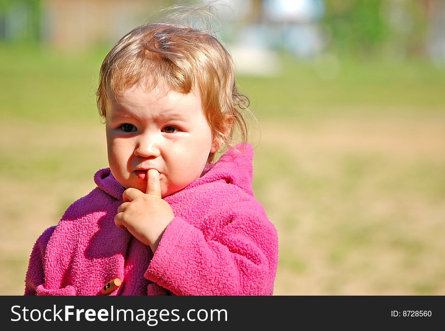 Portrait of the small thinking girl on the nature. Portrait of the small thinking girl on the nature