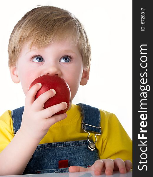 The little boy holds an apple in hands. The little boy holds an apple in hands