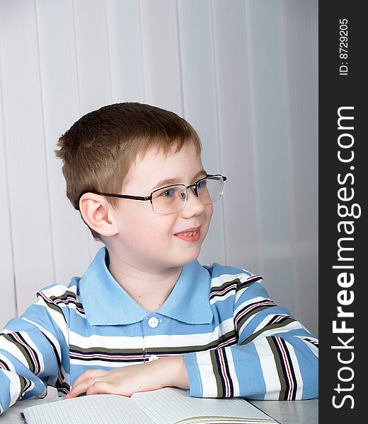 The little boy doing homework on the table. The little boy doing homework on the table