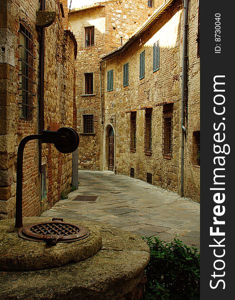 Street of Montepulciano village with a pit in the foreground in Tuscany, Italy. Street of Montepulciano village with a pit in the foreground in Tuscany, Italy