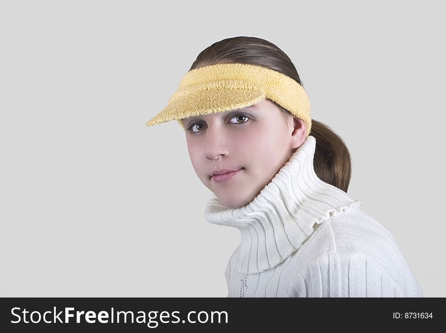 Teenage girl wearing yellow hat,over gray background. Teenage girl wearing yellow hat,over gray background