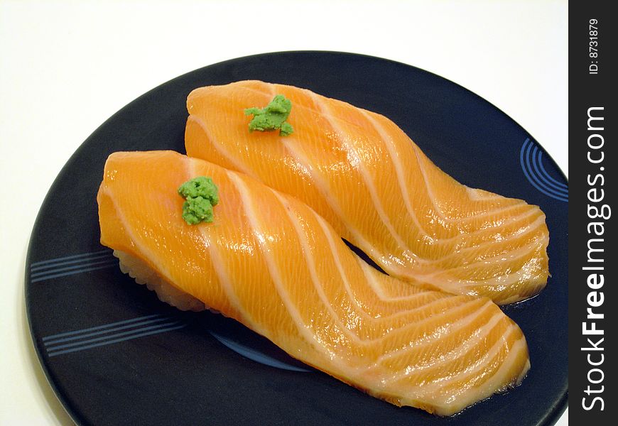 Fresh salmon sushi with wasabi on top