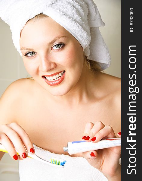 Beautiful young happy woman brushing her teeth in the bathroom. Beautiful young happy woman brushing her teeth in the bathroom