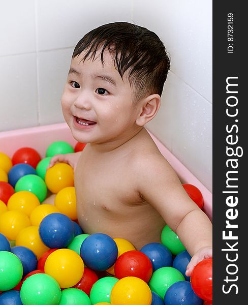 A baby is playing colorful balls. A baby is playing colorful balls