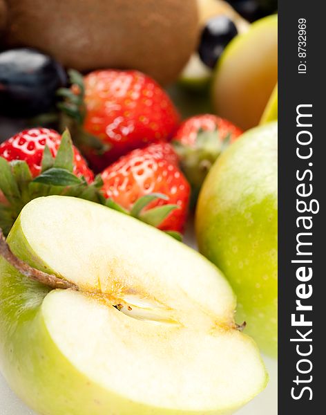 Assorted fresh fruits background including strawberry, apple, kiwi and black and green grape