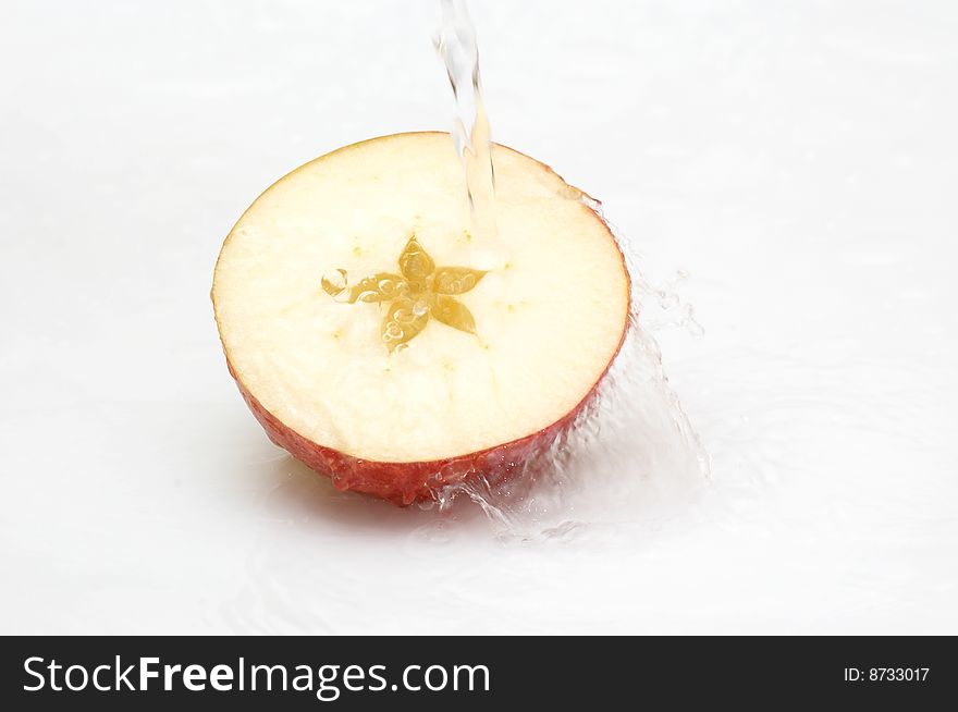 Crystal, clean water splashing on an  ripe apple.