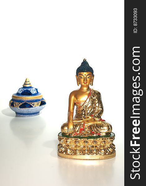 Small statue of a golden buddha isolated on white with an incense burner