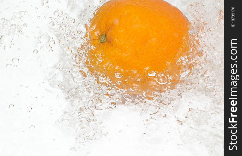 Fresh,tasty orange in streaming water.