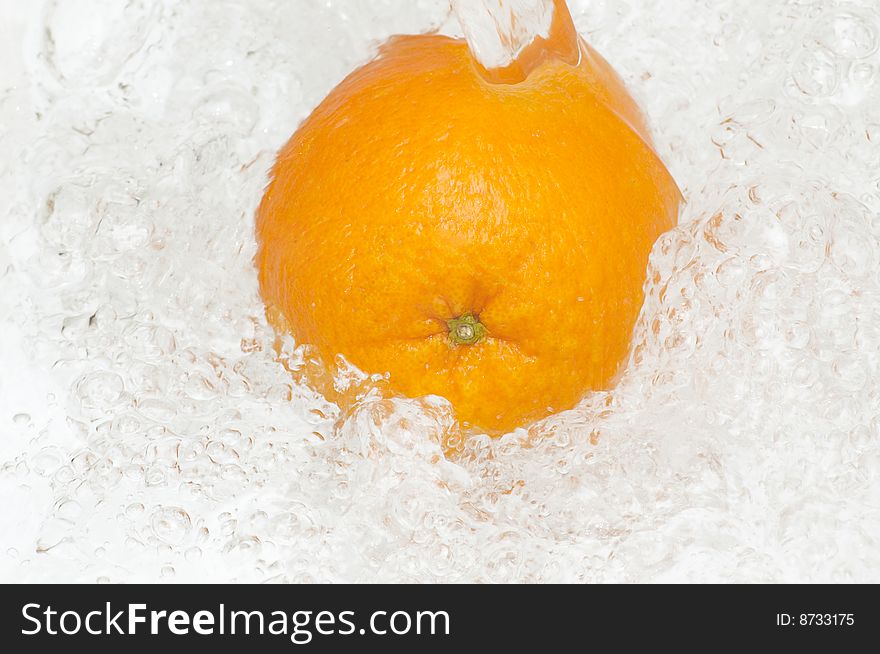 Fresh,juicy orange splashing in cool,clean water.