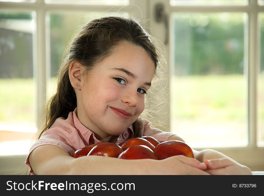 Brown haired child holding apples. Healthy lifstyle image.