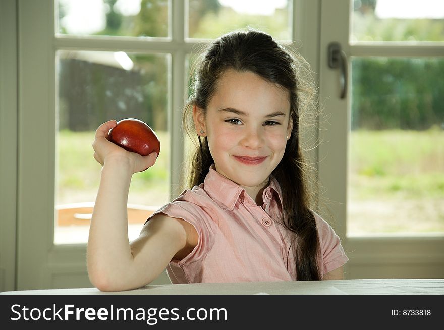 Brown haired child holding an apple. Healthy lifstyle image. Brown haired child holding an apple. Healthy lifstyle image.
