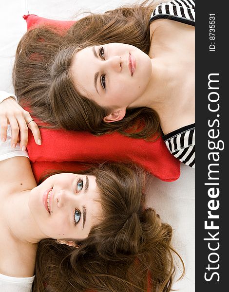 Two girls lying on red pillow