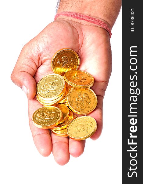 Hand holding gold coins over white background.