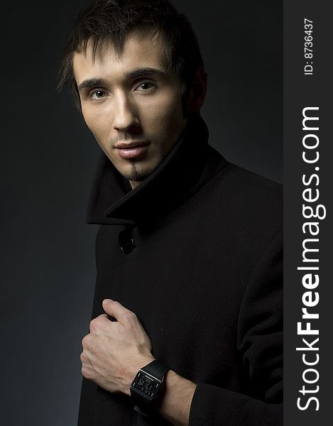 Portrait of a young business man with his hands on a dark background. Portrait of a young business man with his hands on a dark background