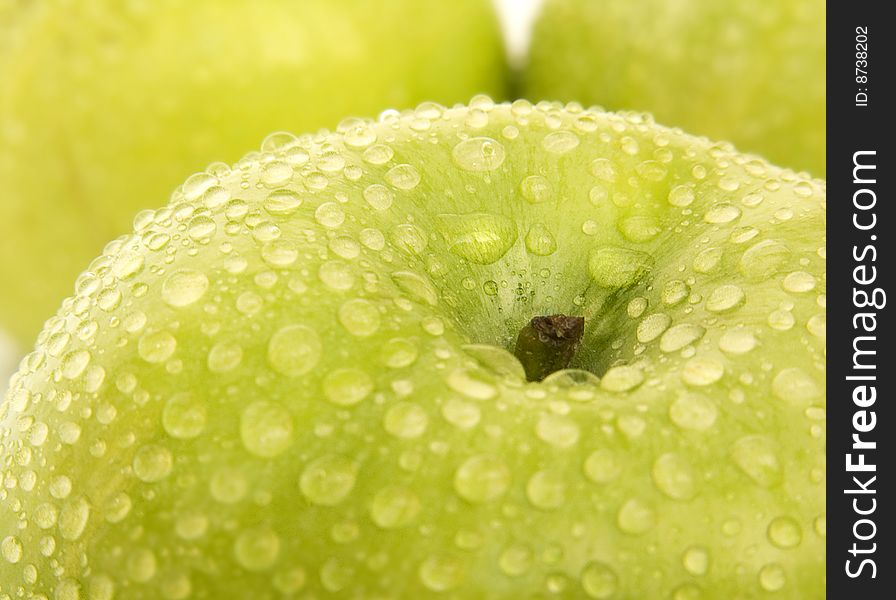 Green apple with drops of water on a dim background