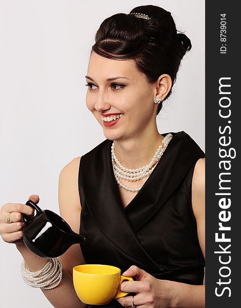 Stylish smiling lady serving tea at breakfast in a classic looking dress isolated on white background. Stylish smiling lady serving tea at breakfast in a classic looking dress isolated on white background