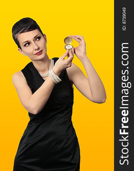 Time for a change. Audrey Hepburn alike holding a classic golden watch looking at copy space isolated on white background