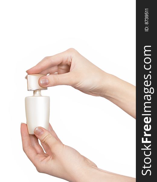 The female hand holds on an open palm a small bottle with perfumery on a white background. The female hand holds on an open palm a small bottle with perfumery on a white background