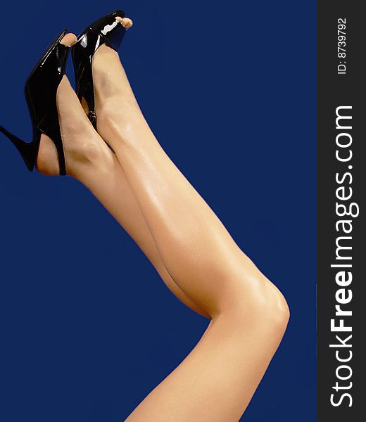 Woman legs and high heels isolated on a dark background