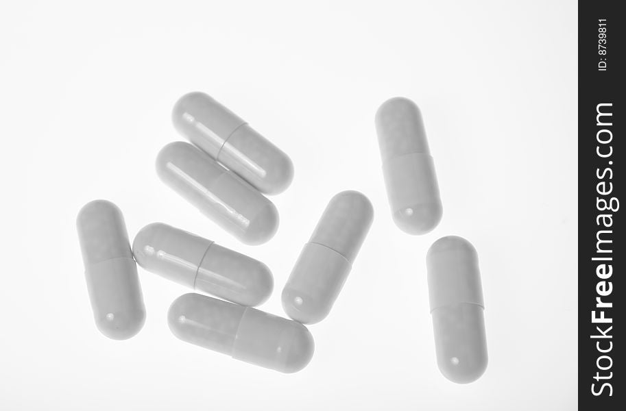 A handful of white pills - capsules on white background