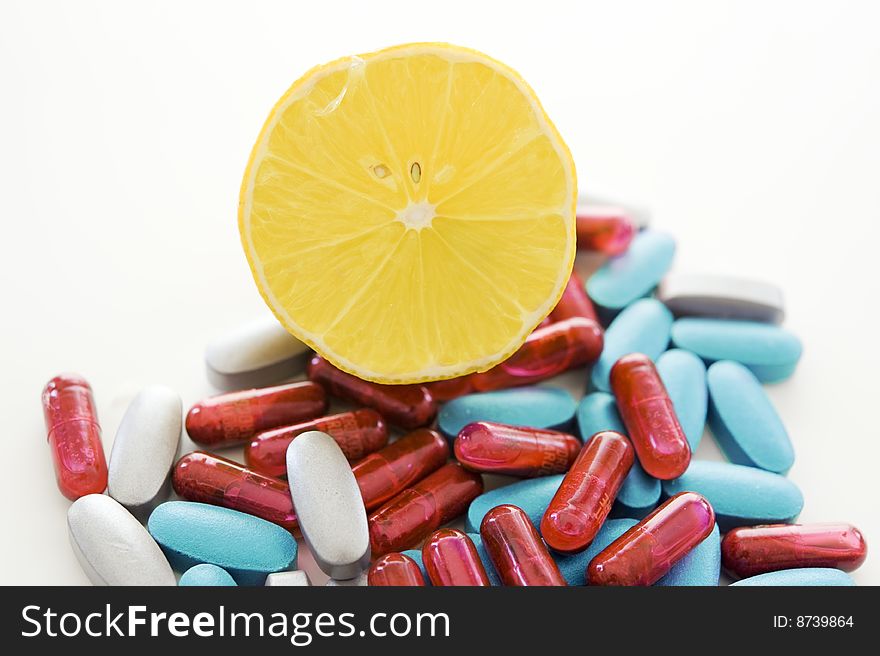 Pills and lemon isolated on white background