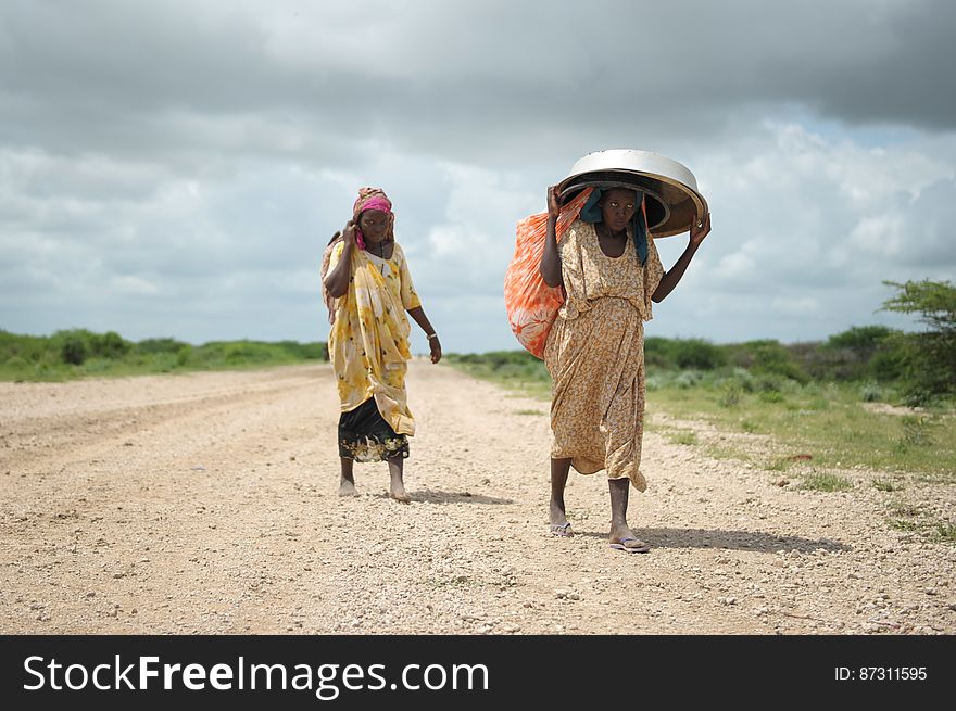 Women, walking with what possesions they can carry, arrive in a steady trickle at an IDP camp erected next to an AMISOM military base near the town of Jowhar, Somalia, on November 12. Heavy rains in Somalia, coupled with recent disputes between clans, has resulted in over four thousand IDPs seeking shelter at an AMISOM military base near the town of Jowhar, with more arriving daily. AU UN IST Photo / Tobin Jones. Women, walking with what possesions they can carry, arrive in a steady trickle at an IDP camp erected next to an AMISOM military base near the town of Jowhar, Somalia, on November 12. Heavy rains in Somalia, coupled with recent disputes between clans, has resulted in over four thousand IDPs seeking shelter at an AMISOM military base near the town of Jowhar, with more arriving daily. AU UN IST Photo / Tobin Jones