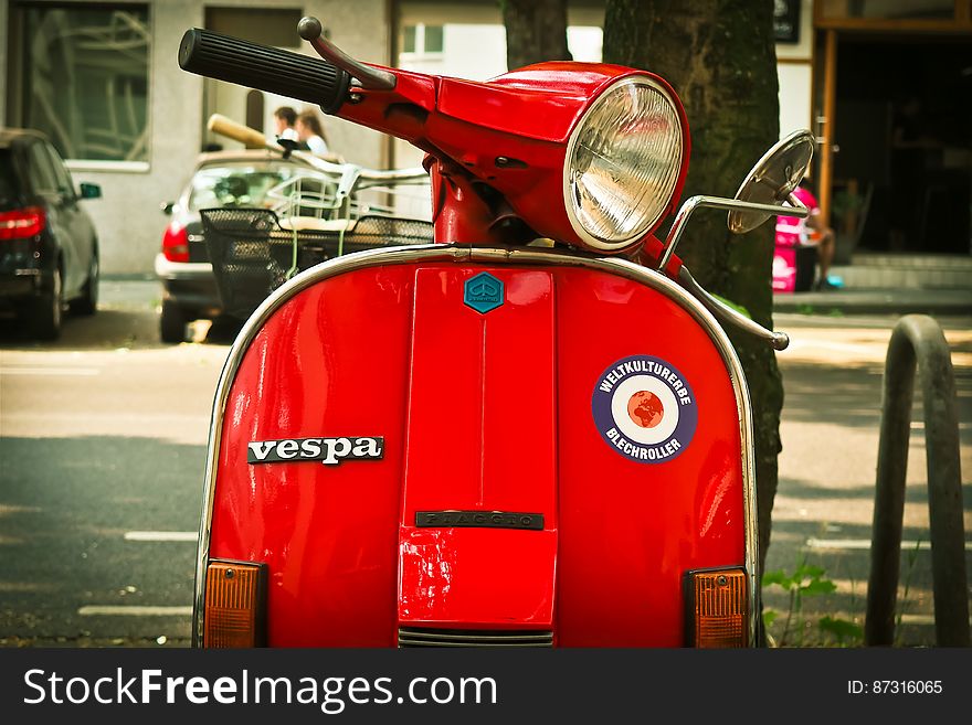 Red Vespa Motor Scooter Parked Near Tree during Daytime
