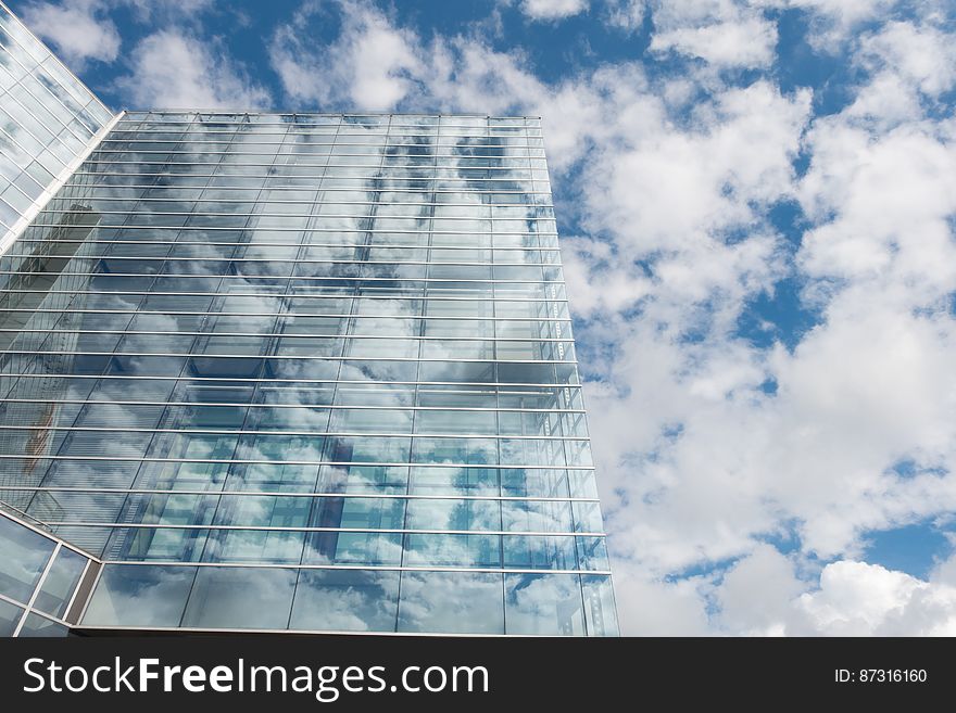 Bottom View Of Clear Glass Building Under Blue Cloudy Sky During Day Time