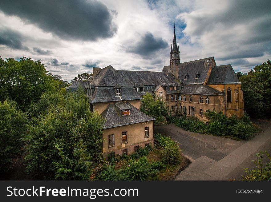 3 Storey Mansion Near Trees Under Cloudy Sky